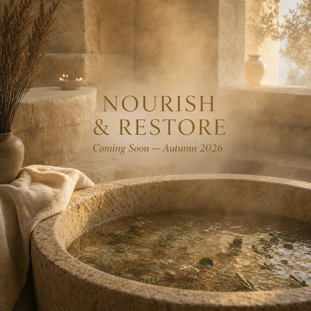 Nourish & Restore collection — stone bath with herbs and warm golden light